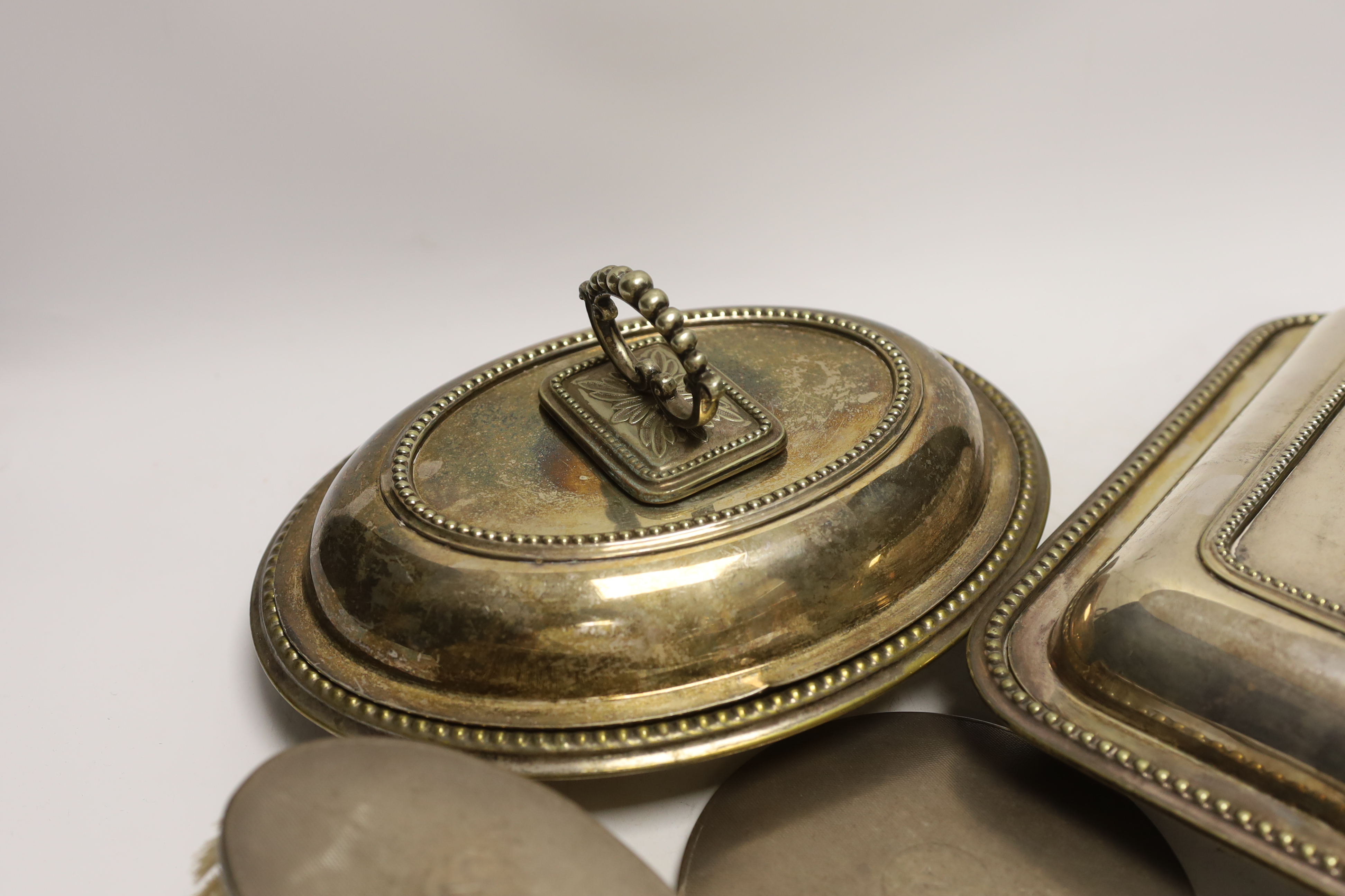 Three plated entrée dishes and a silver dressing table set